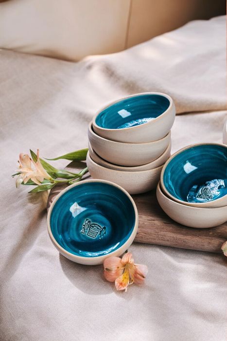 a bunch of bowls that are sitting on a bed