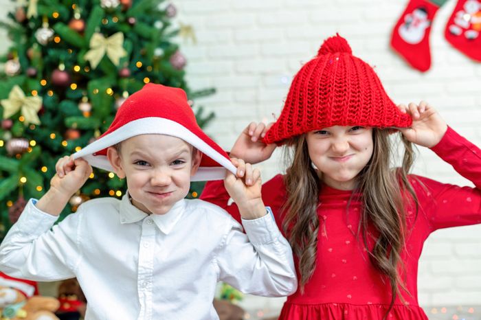 Children playing with funny Christmas hats
