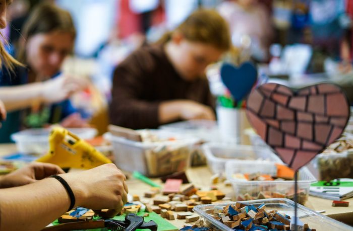 a group of people working on crafts at a table