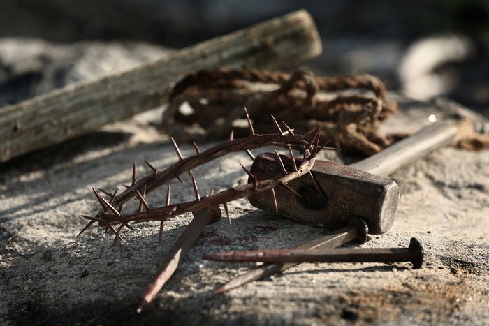A hammer, nail and crown of thorns lie on the ground