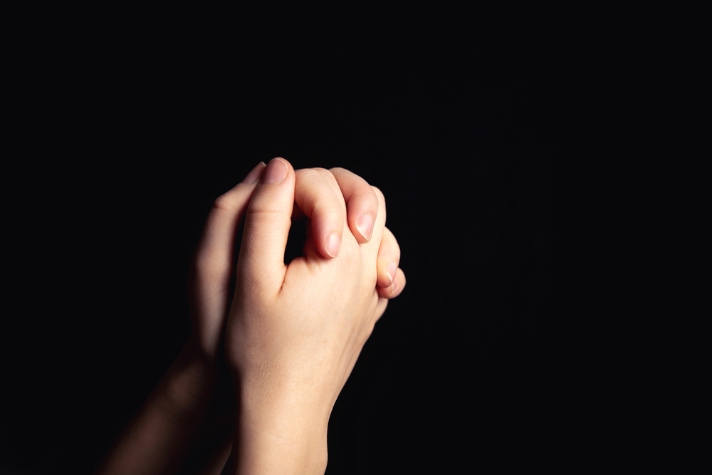 Hands clasped in prayer