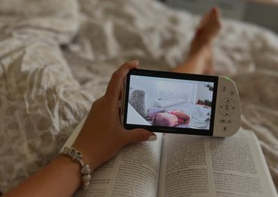 a person laying in bed with a book and a cell phone