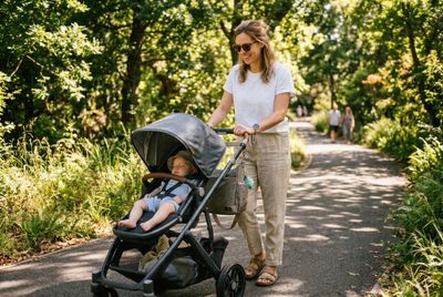 a woman pushing a stroller with a baby in it