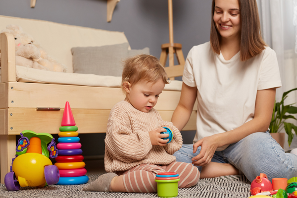 A mother and child sitting on the floor playing with toys