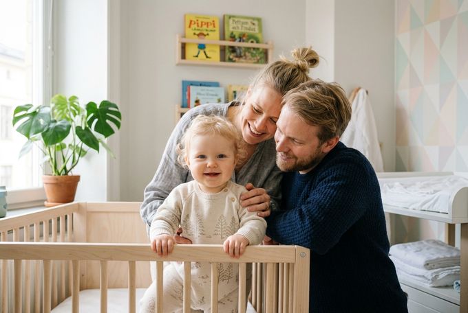 a man and a woman are holding a baby in a crib