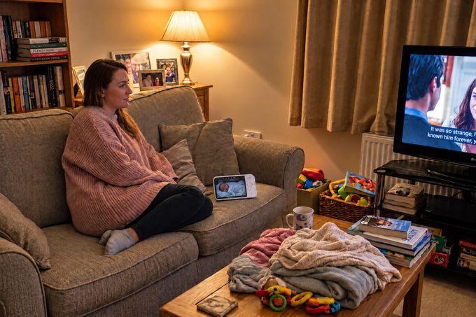 a woman sitting on a couch watching tv