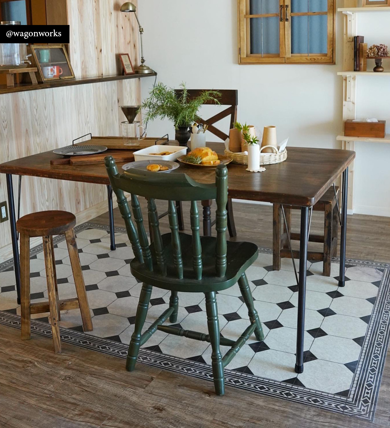 Black and white chessboard-pattern rug under a dining table with a flower vase