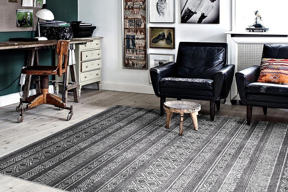 Intricately patterned rug in shades of grey in a study