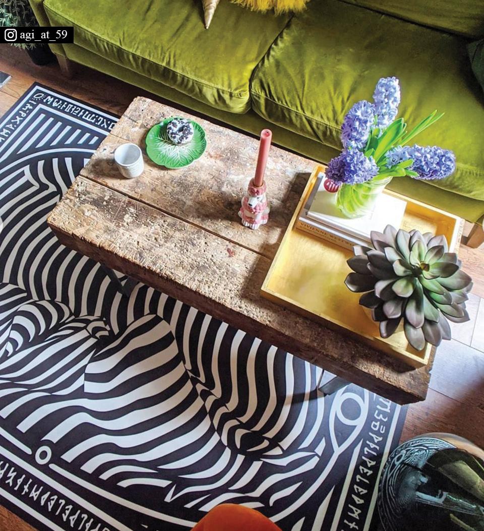 Breath Floor Art by Beija Flor on a living room floor under a coffee table