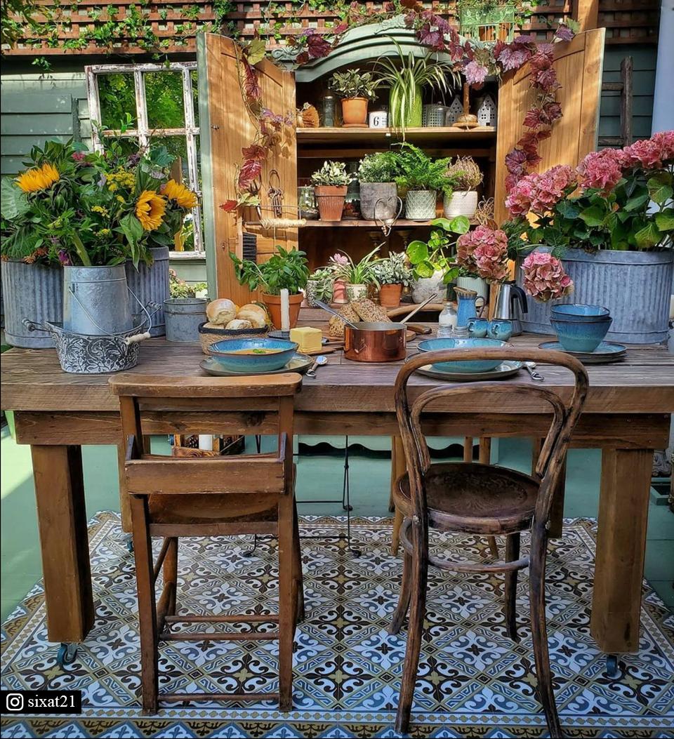 A colorful patterned rug under an outside vintage dining room table