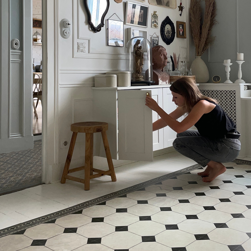 woman squatting over a Black and white chessboard-pattern rug