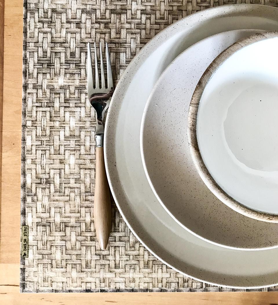 A beige rattan table runner under plates and a fork