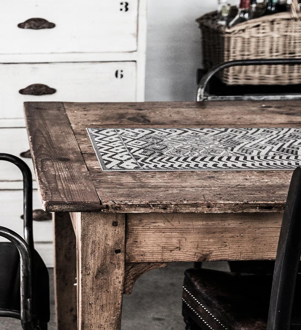 A gray table runner with a stony pattern on a wooden dining room table
