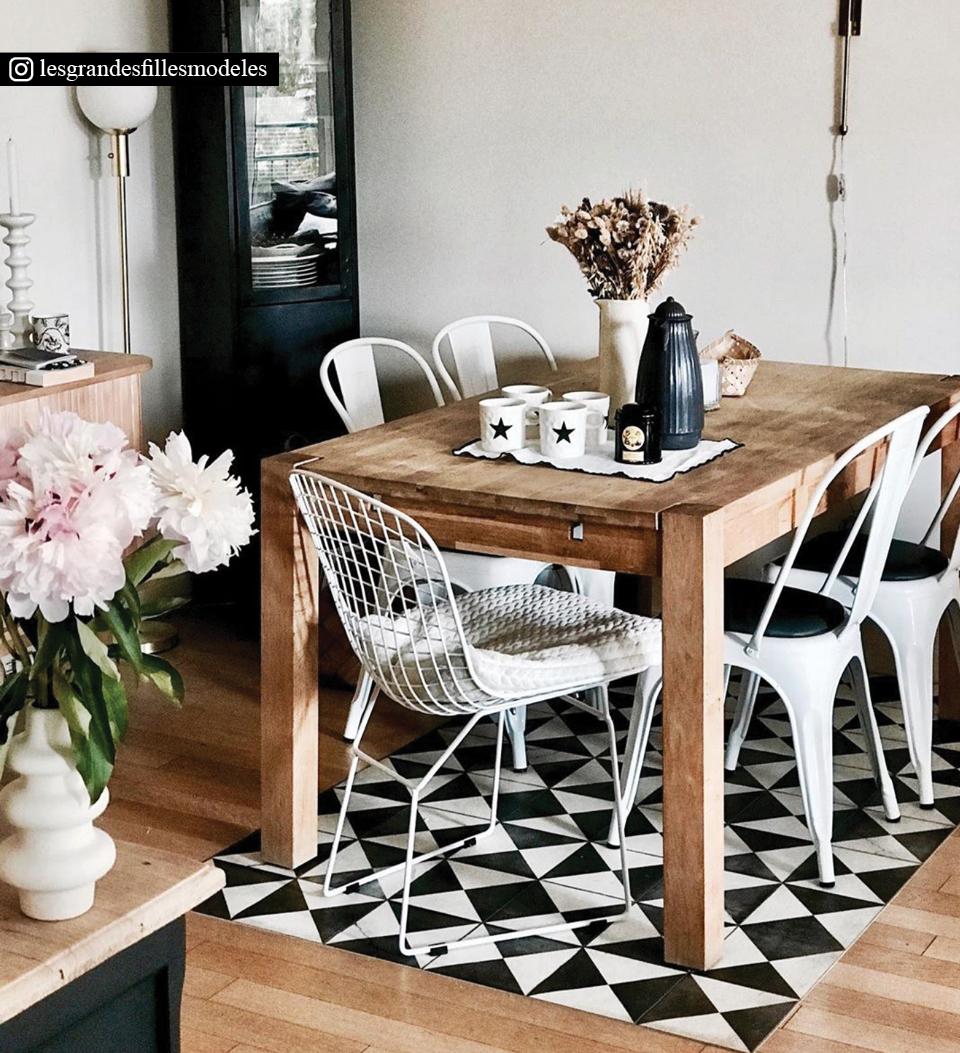 A black and white rug with triangle patterns under a dining room table