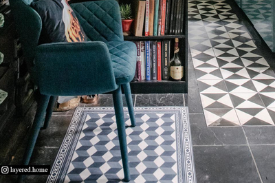 Elegant chequered rug beneath armchair in neat open-plan room
