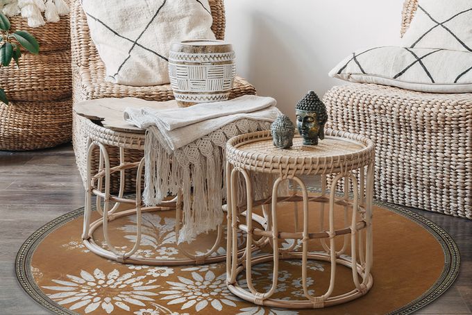 Round rug with a border and warm tones in a living room underneath two small side tables