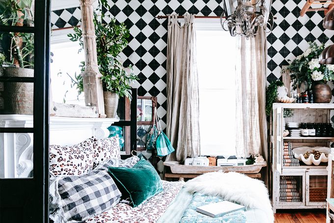 Well decorated living room filled with plants and focused on black and white checkered tile wall