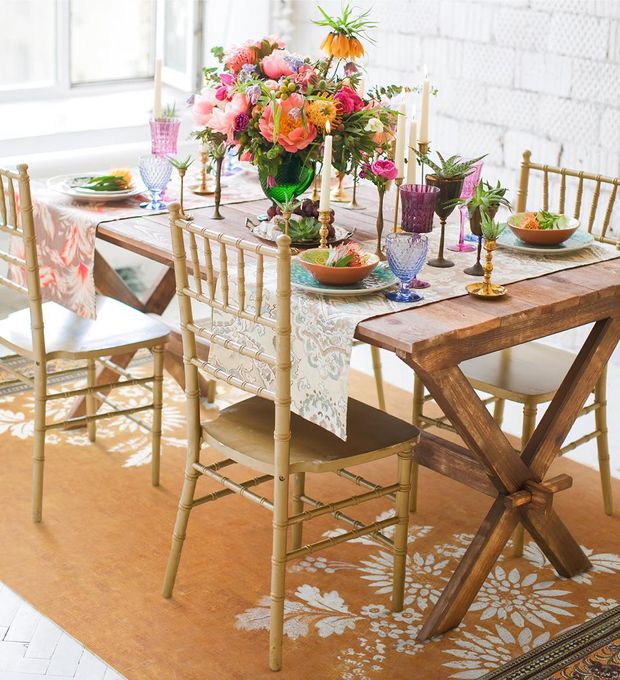 An orange rug with white floral motif under a dining room table