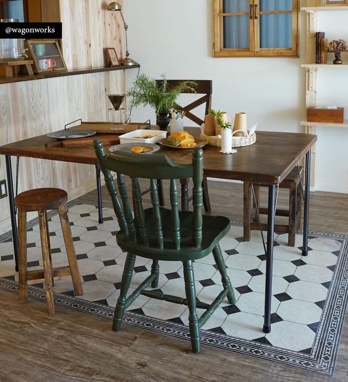 Chessboard-patterned rug in black and white under a dining room table