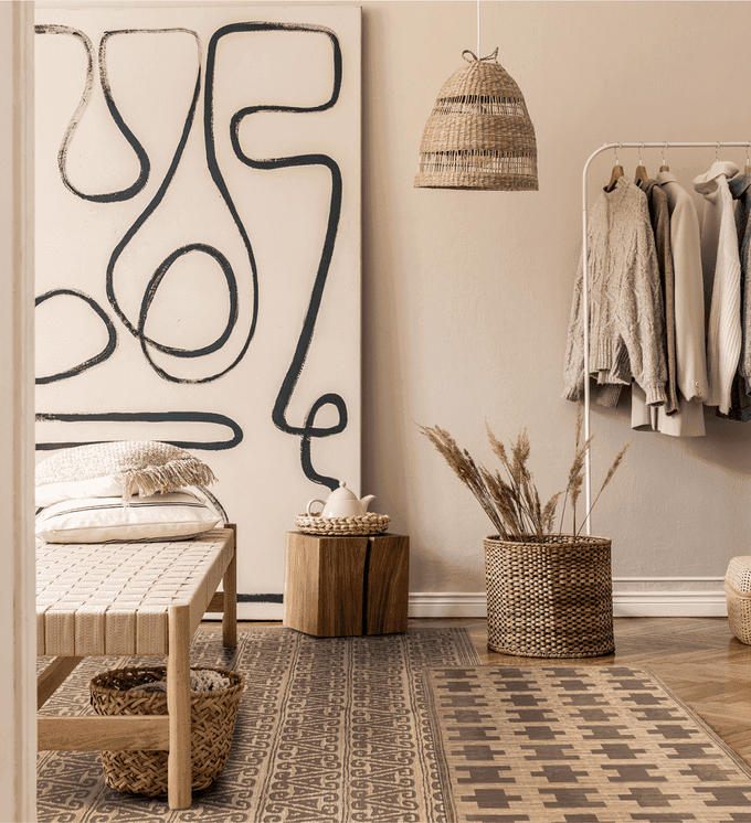 A small beige patterned rug on top of a large differently patterned rug in an open floor space