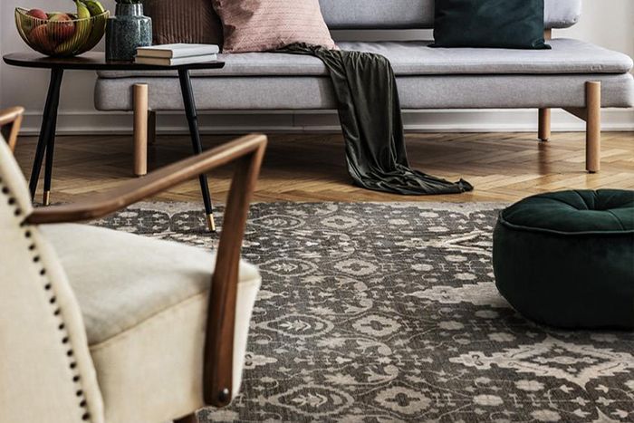 An arm chair and couch on a patterned vinyl rug