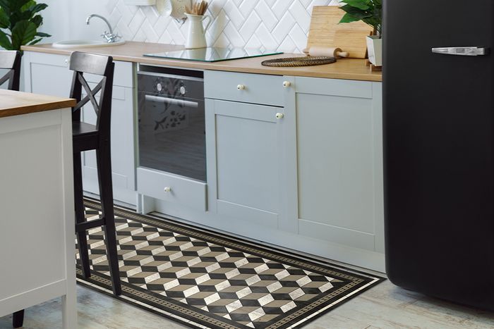 Long geometric pattern rug in a kitchen, placed between the counter and kitchen island