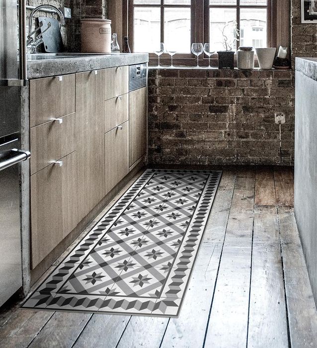 A small runner rug in black and white patterns on a kitchen floor