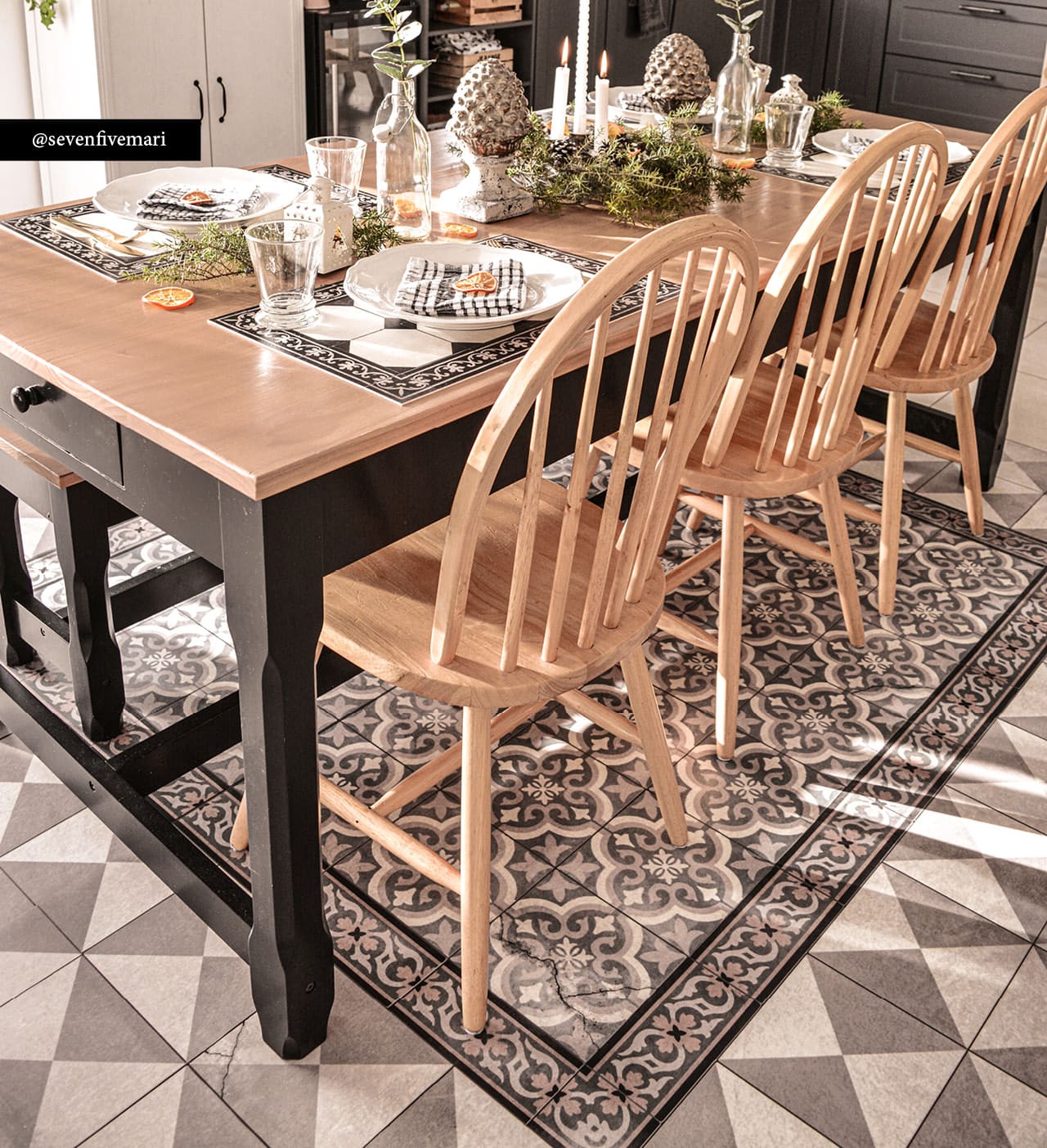 A patterned rug in brown and beige tones under a dining room table