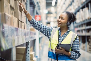 A woman in a warehouse, counting stock