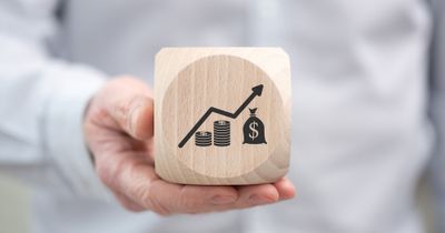Man holding a wooden block with an image of an increasing profit graph