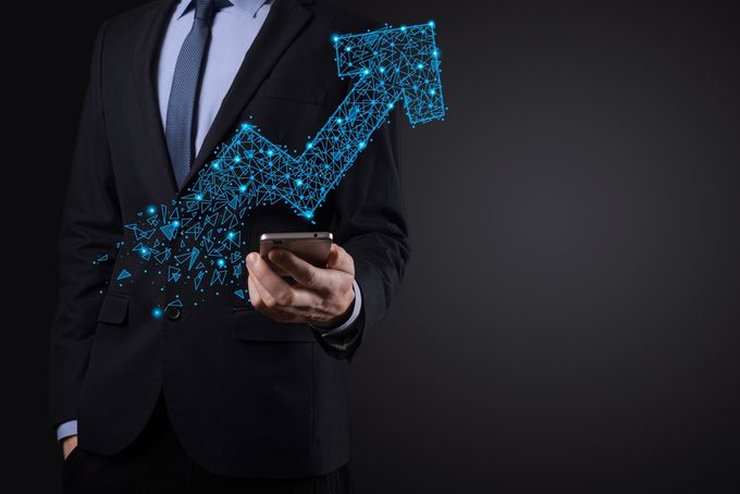 Man holding his cellphone viewing his sales go up