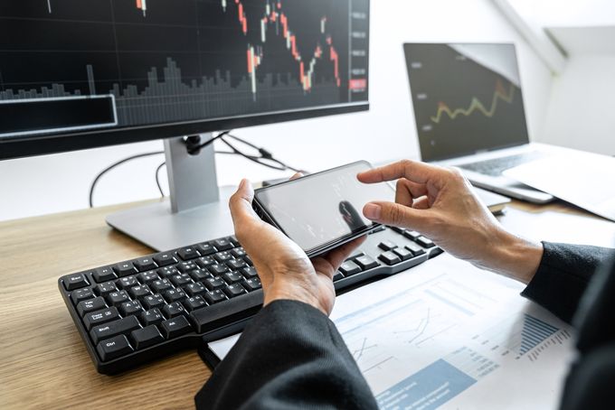 Man holding phone in front of pc