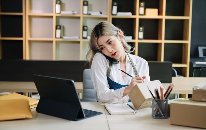 Small business entrepreneur working at home office, BOX, tablet and laptop online.