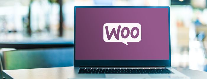 Laptop with purple screen displaying WooCommerce logo