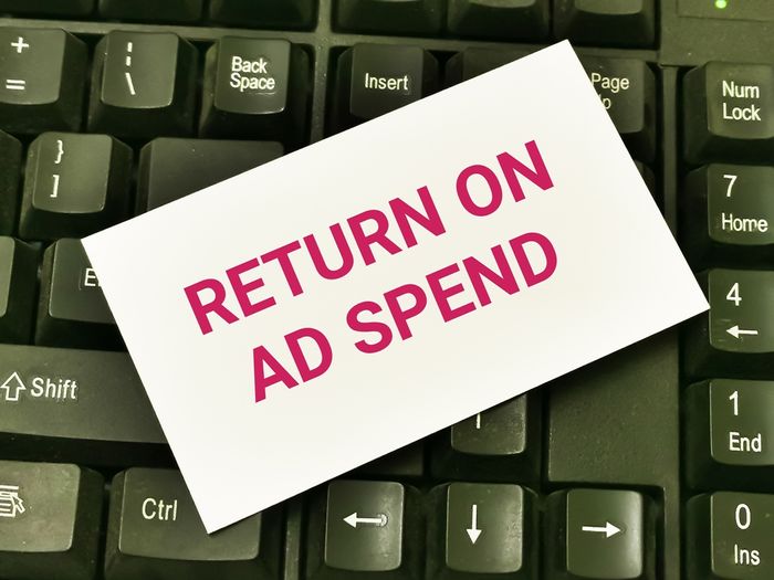 Keyboard with white card on top that reads "Return on Ad Spend"