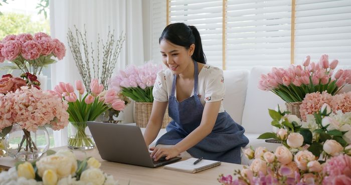 Woman using her laptop in flower shop