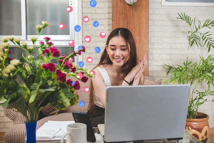 A girl smiling at increased online traffic and likes on her store