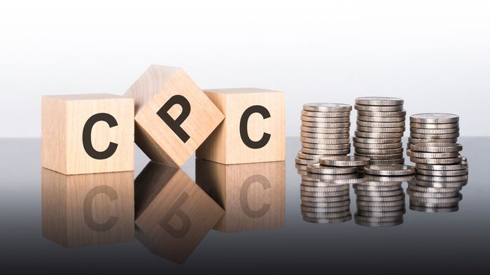 Wooden blocks with 'CPC' on them next to stacks of coins