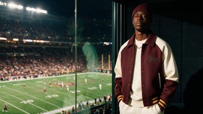 a man standing in front of a window at a football game