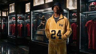 a man standing in front of a display of football uniforms