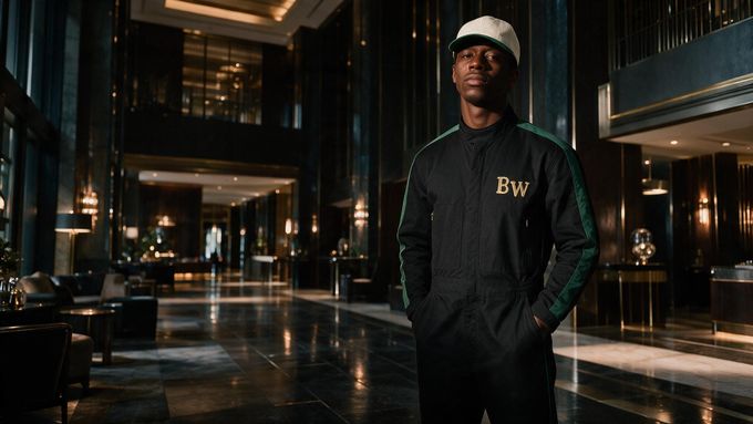 a man in a black and green outfit standing in a lobby