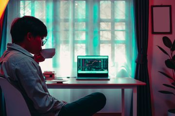 Man comparing results of different trading platforms