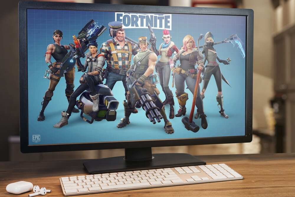 A computer screen displaying the Fortnite logo, along with several of its characters, against a blue background.