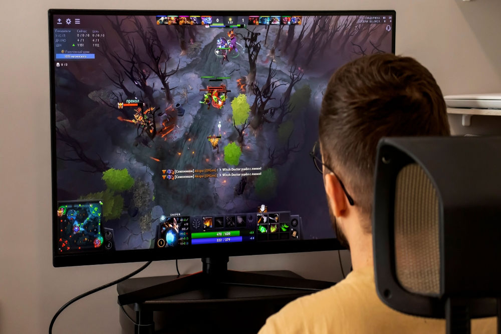 A PC gamer seated at his desk, playing Dota 2.