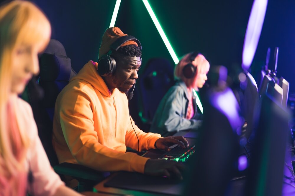 Three PC gamers seated next to each other, competing at an eSports tournament.