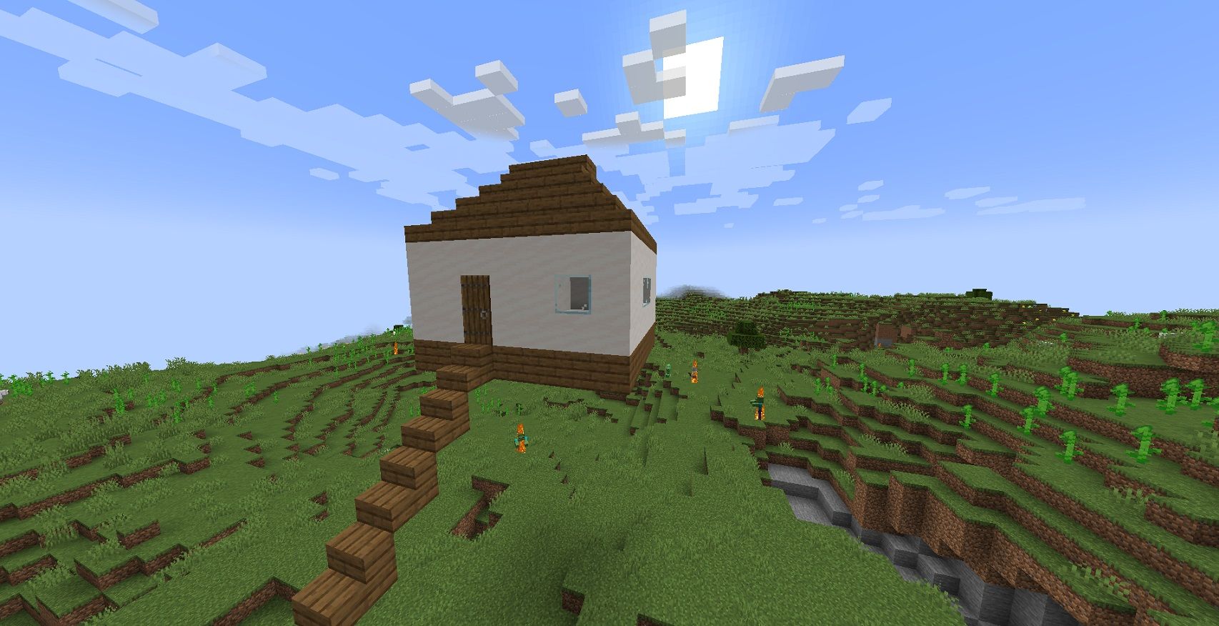 A small Minecraft house in the middle of an open field