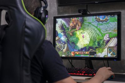 A gamer playing League of Legends on gaming PC after purchasing some Mythic Skins