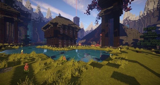 A grassy area with a lake, with some buildings made of wooden blocks