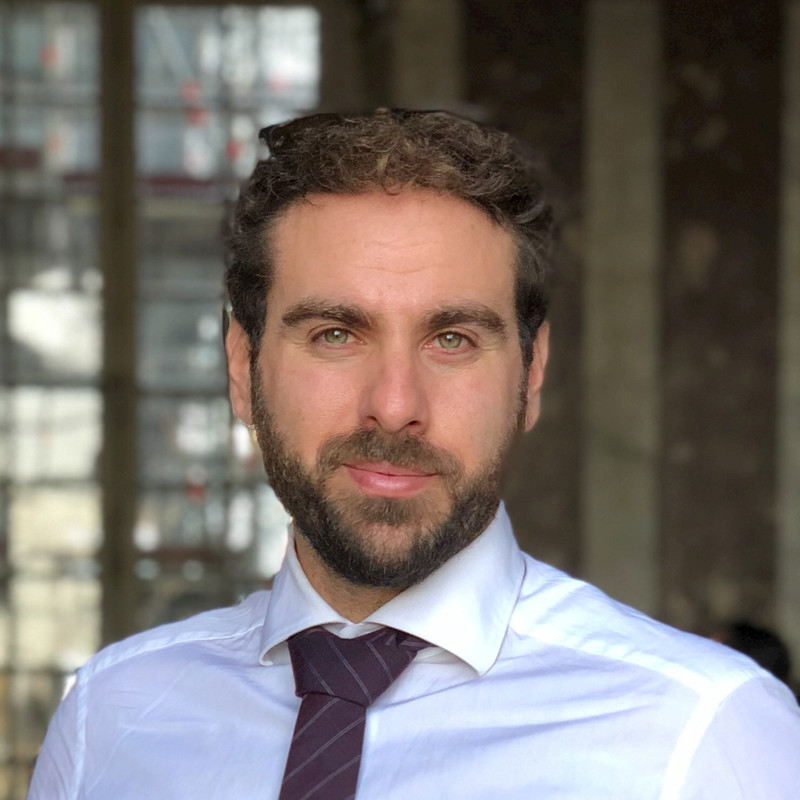 a man with a beard wearing a white shirt and tie