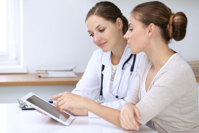 a doctor and patient looking at a CMS on ipad